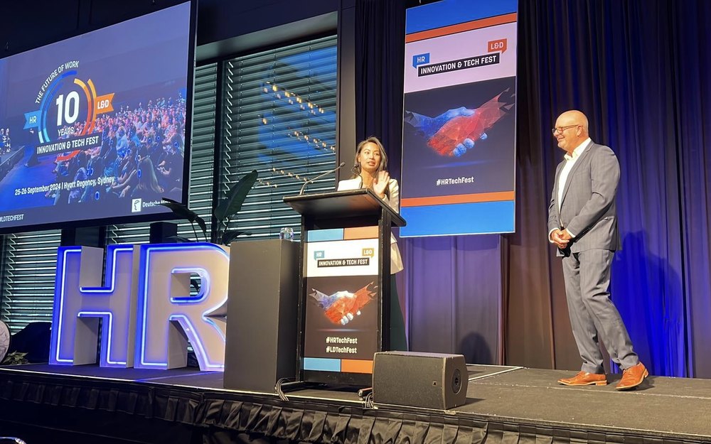 Nikki Tugano accepting the win on stage at the HR + L&D Innovation & Tech Fest 2024, Sydney