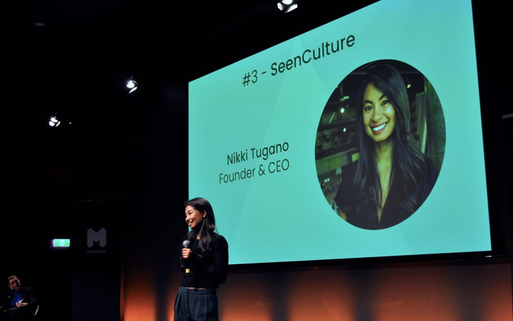 Nikki Tugano pitching SeenCulture on stage in Melbourne